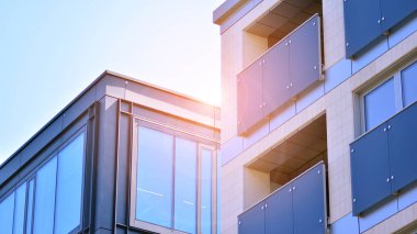 Bir konut binası ve bitişik bir ofis binası. Modern şehir gelişimi. Mavi gökyüzüne ve güneş ışığına karşı binalar. 