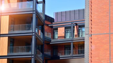 Tuğla yüzlü bir apartmanın mimari dış görünüşü. Apartmanın modern tuğla ve cam cephesi.