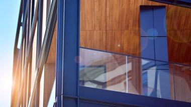 Binanın çelik ve cam metal cephesinin bir parçası. Açık mavi gökyüzü arka planında çelik ve cam cephe mimarisini detaylandır. Balkonlu modern mimari bina cephesi. Yeni daireler