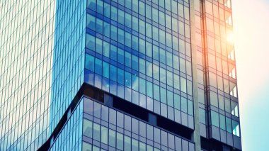Şehirde günışığı olan modern bir bina. Modern ofis binasında soyut doku ve mavi cam cephe, Retro renkli tonik filtre efekti.