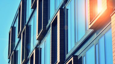 Şehirde günışığı olan modern bir bina. Modern ofis binasında soyut doku ve mavi cam cephe, Retro renkli tonik filtre efekti.