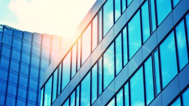 Şehirde günışığı olan modern bir bina. Modern ofis binasında soyut doku ve mavi cam cephe, Retro renkli tonik filtre efekti.