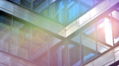 Güneş ışınlı modern mimari. Parlak güneşli bir günde mavi gökyüzünde güneş ışınları olan cam ve çelik cephe. Ekonomi, finans, iş faaliyeti kavramı.