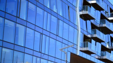 Ofis binasının ön cephesinin aynalı pencereleri. Mavi cam modern ofis binasının soyut dokusu. İş geçmişi.