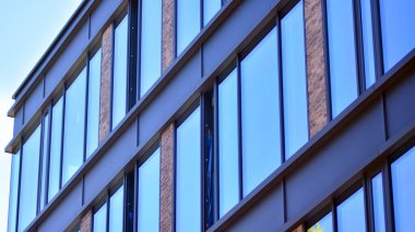 Ofis binasının ön cephesinin aynalı pencereleri. Mavi cam modern ofis binasının soyut dokusu. İş geçmişi.