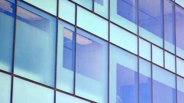 Mirrored windows of the facade of an office building. Abstract texture of blue glass modern office building. Business background.