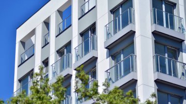 Simetrik modern mimarisi olan apartman ve apartman dairesi. Modern apartman dairesinin dış cephesindeki detaylar. Yeni lüks ev ve ev kompleksi.. 