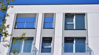 Simetrik modern mimarisi olan apartman ve apartman dairesi. Modern apartman dairesinin dış cephesindeki detaylar. Yeni lüks ev ve ev kompleksi.. 