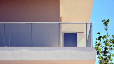 Simetrik modern mimarisi olan apartman ve apartman dairesi. Modern apartman dairesinin dış cephesindeki detaylar. Yeni lüks ev ve ev kompleksi.. 