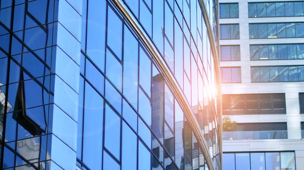 Glass facade of the buildings with a blue sky. Skyscrapers in the business city center.. Background of modern glass buildings.