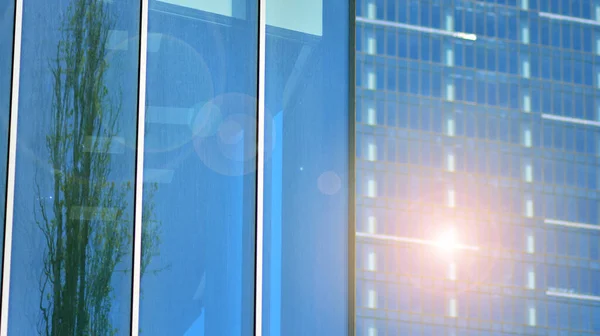 Glass facade of the buildings with a blue sky. Skyscrapers in the business city center.. Background of modern glass buildings.