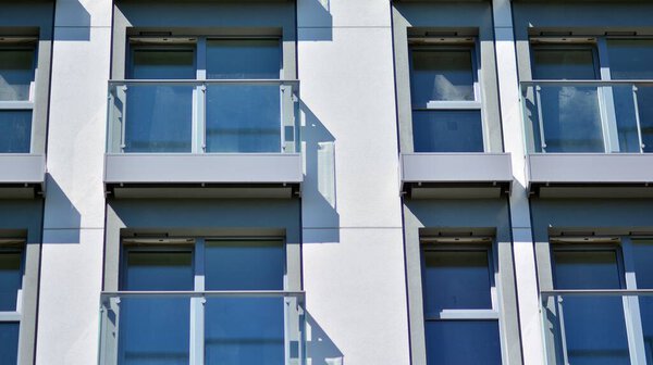 Condominium and apartment building with symmetrical modern architecture. Detail in modern residential flat apartment building exterior. Fragment of new luxury house and home complex.