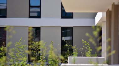 Simetrik modern mimarisi olan apartman ve apartman dairesi. Modern apartman dairesinin dış cephesindeki detaylar. Yeni lüks ev ve ev kompleksi..