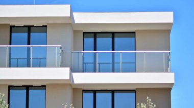 Simetrik modern mimarisi olan apartman ve apartman dairesi. Modern apartman dairesinin dış cephesindeki detaylar. Yeni lüks ev ve ev kompleksi..