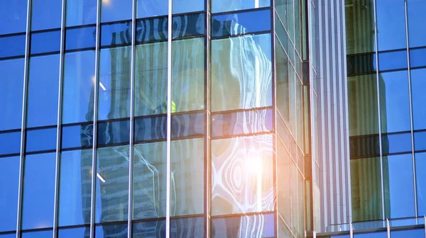 Glass facade of the buildings with a blue sky. Skyscrapers in the business city center.. Background of modern glass buildings.