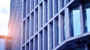 Modern cam ve beton binaya bakmanın soyut görüntüsü. Ofis binasının mimari dış ayrıntıları. Endüstriyel sanat ve detay. Gün doğumu.