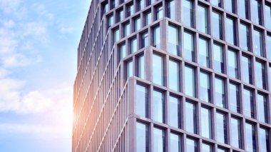 Modern cam ve beton binaya bakmanın soyut görüntüsü. Ofis binasının mimari dış ayrıntıları. Endüstriyel sanat ve detay. Gün doğumu.