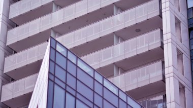 Yansıtıcı camlarla kaplı modern bir binanın cam kaplamalı dış cephesinin soyut yakın çekimi. Mimari soyut arkaplan. Cam duvar ve ön cephe ayrıntıları.