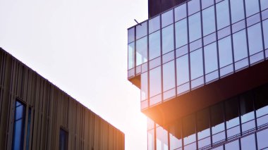 Mavi gökyüzüne karşı modern gökdelenlerin alt manzarası. Şehir merkezindeki iş binalarına bakıyorum..  