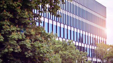 Ön cephenin bir parçası. Cam aynalı ofis binasının ön dokusu. Gündoğumunda ışık, mercekle parlıyor.. 