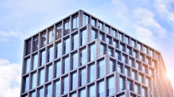 Modern cam ve beton binaya bakmanın soyut görüntüsü. Ofis binasının mimari dış ayrıntıları. Endüstriyel sanat ve detay. Gün doğumu.