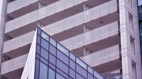 Yansıtıcı camlarla kaplı modern bir binanın cam kaplamalı dış cephesinin soyut yakın çekimi. Mimari soyut arkaplan. Cam duvar ve ön cephe ayrıntıları.