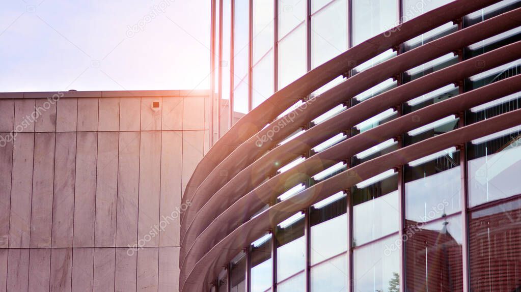 Fragment of the facade.  Facade texture of a glass mirrored office building. Light at sunrise with lens flare. 