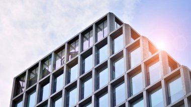 Modern cam ve beton binaya bakmanın soyut görüntüsü. Ofis binasının mimari dış ayrıntıları. Endüstriyel sanat ve detay. Gün doğumu.