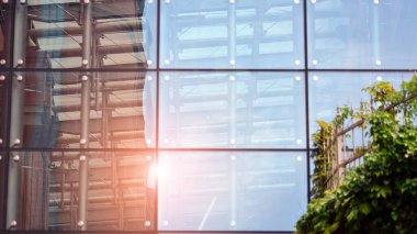 Ön cephenin bir parçası. Cam aynalı ofis binasının ön dokusu. Gündoğumunda ışık, mercekle parlıyor.. 