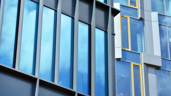 Glass facade of the buildings with a blue sky. Modern building in the business city center. Background of modern glass buildings.