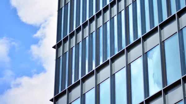 Glass facade of the buildings with a blue sky. Modern building in the business city center. Background of modern glass buildings.