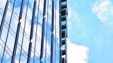 Glass and aluminum facade of a modern office building. View of futuristic architecture. Office building with cloud reflection on windows