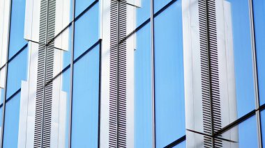Glass and aluminum facade of a modern office building. View of futuristic architecture. Office building with cloud reflection on windows
