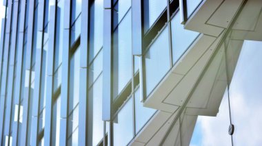 Glass and aluminum facade of a modern office building. View of futuristic architecture. Office building with cloud reflection on windows