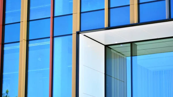 Glass facade of the buildings with a blue sky. Modern building in the business city center. Background of modern glass buildings.