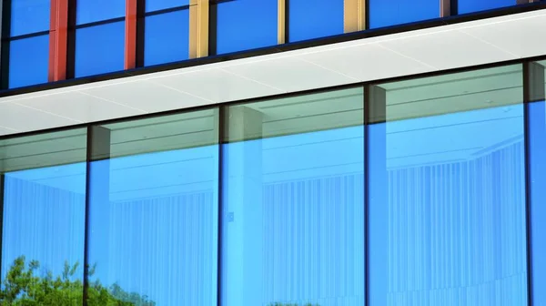 Glass facade of the buildings with a blue sky. Modern building in the business city center. Background of modern glass buildings.