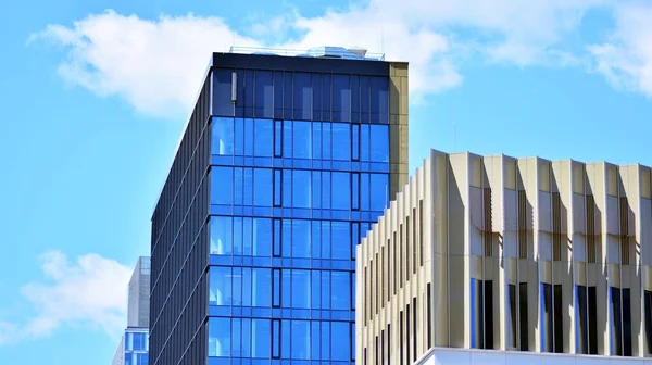 Glass facade of the buildings with a blue sky. Modern building in the business city center. Background of modern glass buildings.