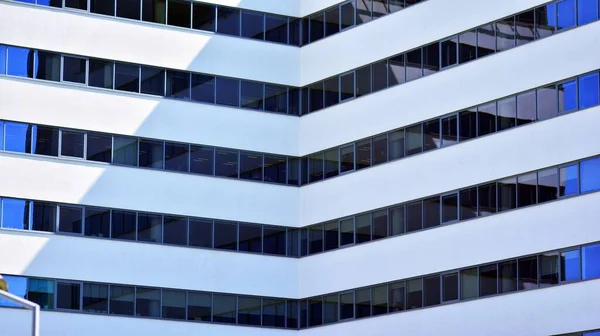 Glass facade of the buildings with a blue sky. Modern building in the business city center. Background of modern glass buildings.