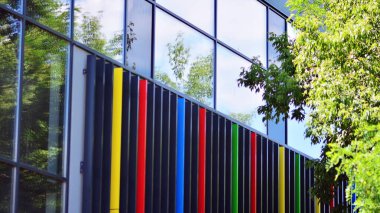 Çevre mimarisi. Yeşil ağaç ve cam ofis binası. Doğanın ve modernliğin ahengi.