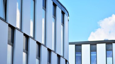 Yansıtıcı camlarla kaplı modern bir binanın cam kaplamalı dış cephesinin soyut yakın çekimi. Mimari soyut arkaplan. Cam duvar ve ön cephe ayrıntıları.