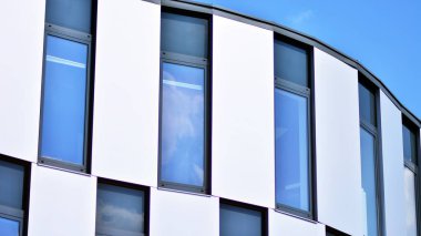 Yansıtıcı camlarla kaplı modern bir binanın cam kaplamalı dış cephesinin soyut yakın çekimi. Mimari soyut arkaplan. Cam duvar ve ön cephe ayrıntıları.