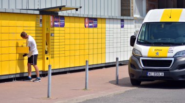 Varşova, Polonya. 9 Temmuz 2021. Kurye InPost otomatik self servis terminal makinesine paket teslim et