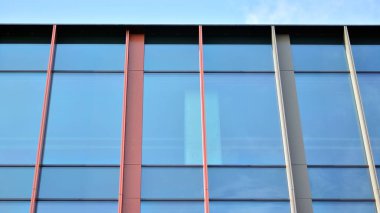 Gökyüzü yansıyan bir ofis binasının camlı cephesi. Modern mimari binalar dış görünüş 