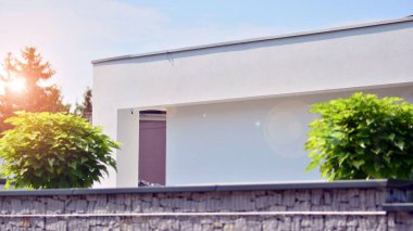 Tek bir aile binasının parçası. Pencereleri ve yeşili olan modern evin yan tarafında. Büyük lüks bir evin parçası..