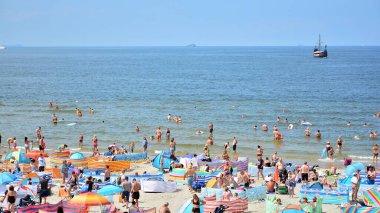 Miedzyzdroje, Polonya. 22 Temmuz 2021. Plaj manzarası. Sıcak yaz günlerinde turistler, güneşli yataklar ve rüzgarlıklar. Turistler yazın plajda güneşlenir, dinlenir ve denizde yüzerler..