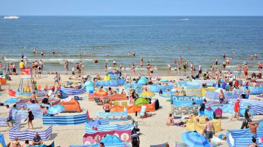 Miedzyzdroje, Polonya. 22 Temmuz 2021. Plaj manzarası. Sıcak yaz günlerinde turistler, güneşli yataklar ve rüzgarlıklar. Turistler yazın plajda güneşlenir, dinlenir ve denizde yüzerler..
