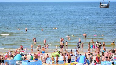 Miedzyzdroje, Polonya. 22 Temmuz 2021. Plaj manzarası. Sıcak yaz günlerinde turistler, güneşli yataklar ve rüzgarlıklar. Turistler yazın plajda güneşlenir, dinlenir ve denizde yüzerler..