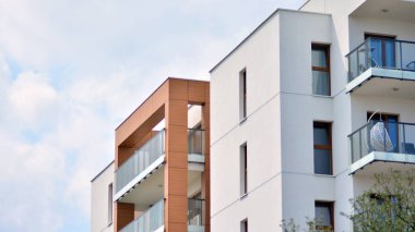 Cam balkonlu yeni apartman. Deniz kenarındaki modern mimari evler. Binanın ön cephesinde büyük camlar var..