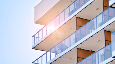 Cam balkonlu yeni apartman. Deniz kenarındaki modern mimari evler. Binanın ön cephesinde büyük camlar var..