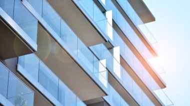 Cam balkonlu yeni apartman. Deniz kenarındaki modern mimari evler. Binanın ön cephesinde büyük camlar var..